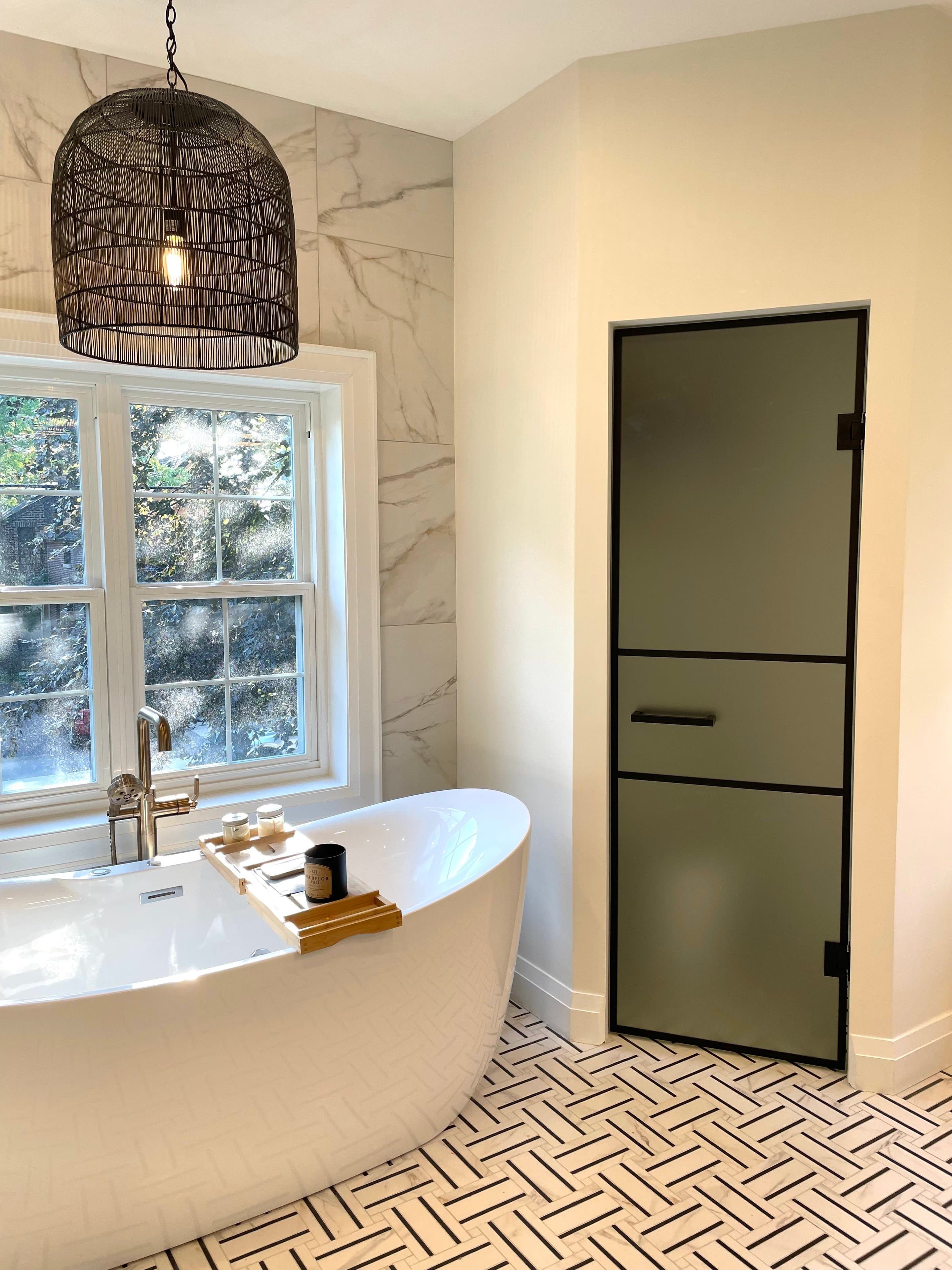 Modern bathroom with marble walls and sleek freestanding tub.